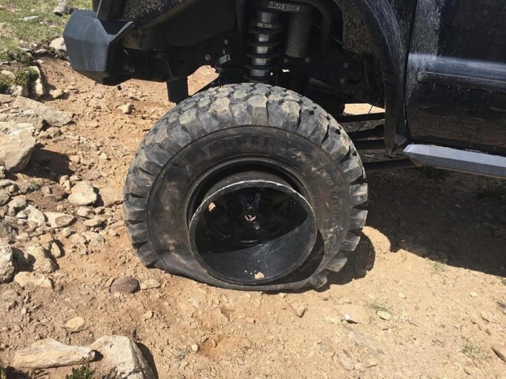 Kingston Peak: Truck with 43s and sliced sidewalls and stripped lug nuts.